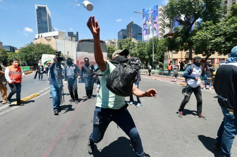 Video: Manifestación por los 43 afuera de la FGR termina con encapuchados lanzando piedras y cohetones al inmueble de la institución y policías; 5 lesionados