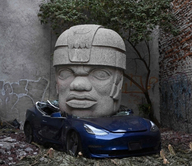 Auto eléctrico Tesla, de 40 mil dólares, aplastado por cabeza Olmeca de tres toneladas, obra artística provocadora, exhibida en España